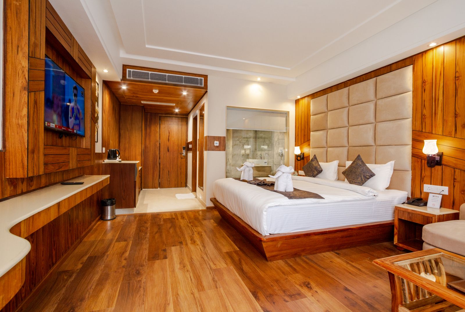Eksempel på hotellrom med tregulv, dobbeltseng og innredning i tre
