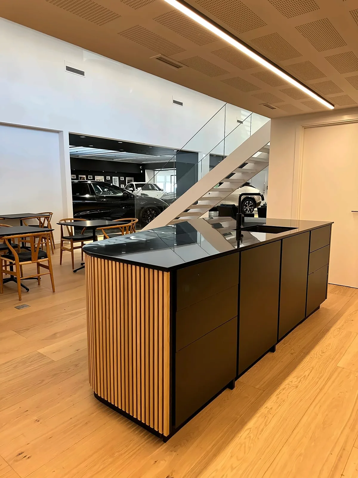 Køkkenø i ribbet egetræ med sort bordplade i showroom hos Andersen Biler i Gladsaxe